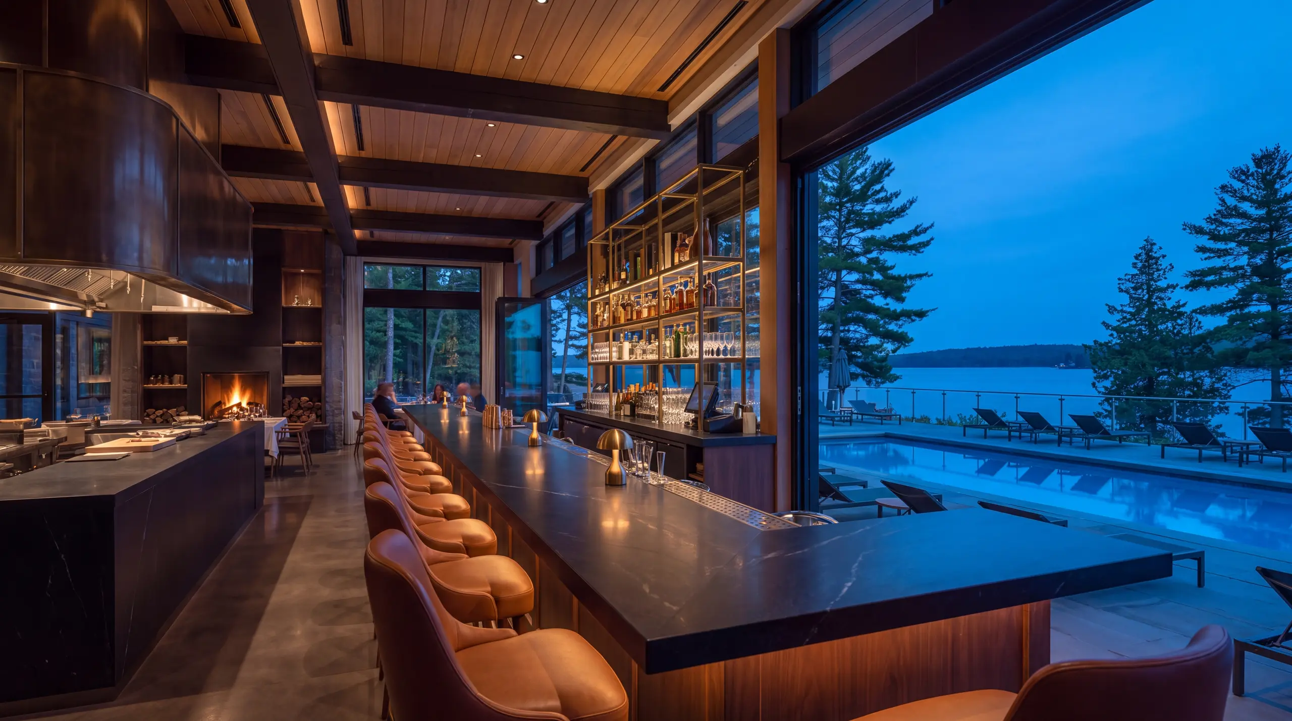 Long dark soapstone lounge bar leading toward the connected outdoor pool and Lake Muskoka
